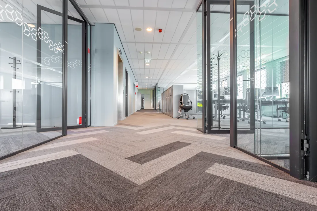 Bright corridor with glass meeting rooms in a commercial office