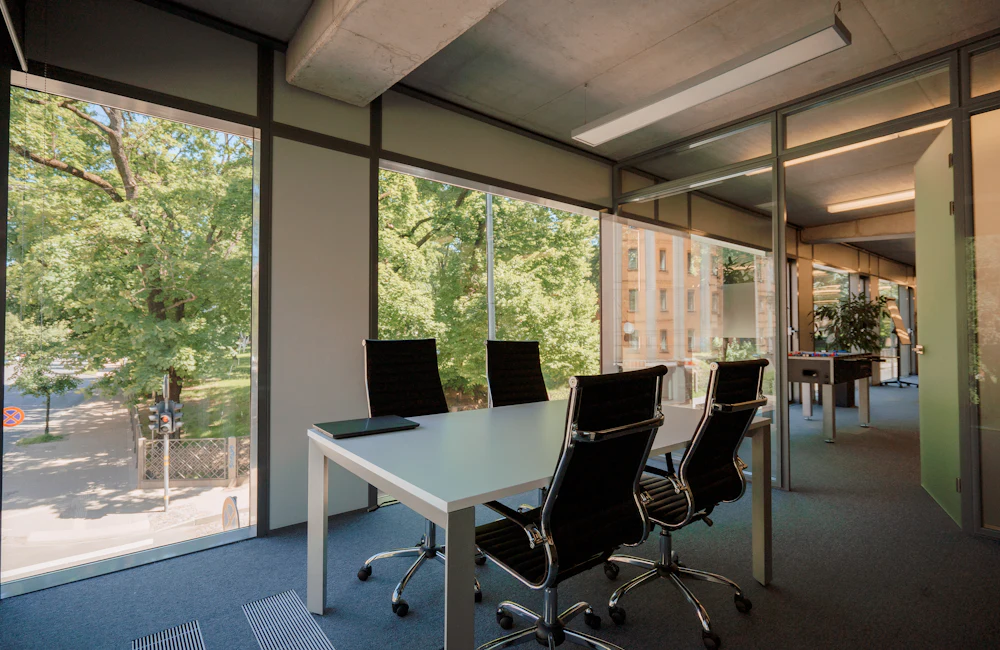 Modern office meeting room with desks and large windows